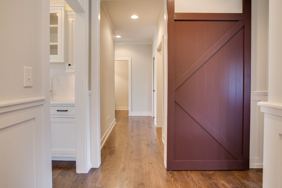 This is an example of an arts and crafts hallway in Other with grey walls and medium hardwood floors.