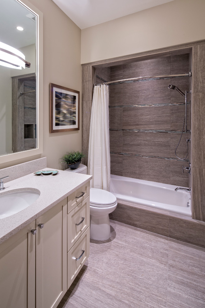 Large beach style bathroom in Miami with an undermount sink, shaker cabinets, white cabinets, engineered quartz benchtops, an alcove tub, a shower/bathtub combo, beige tile, porcelain tile, white walls and porcelain floors.