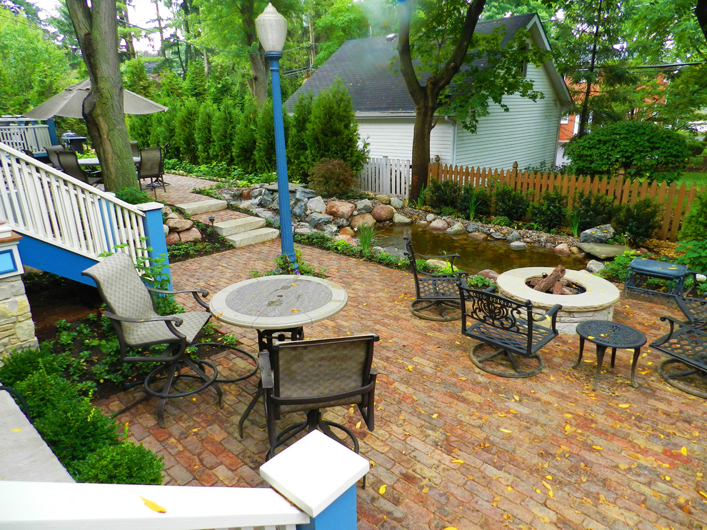 Design ideas for a mid-sized traditional backyard patio in Chicago with brick pavers.