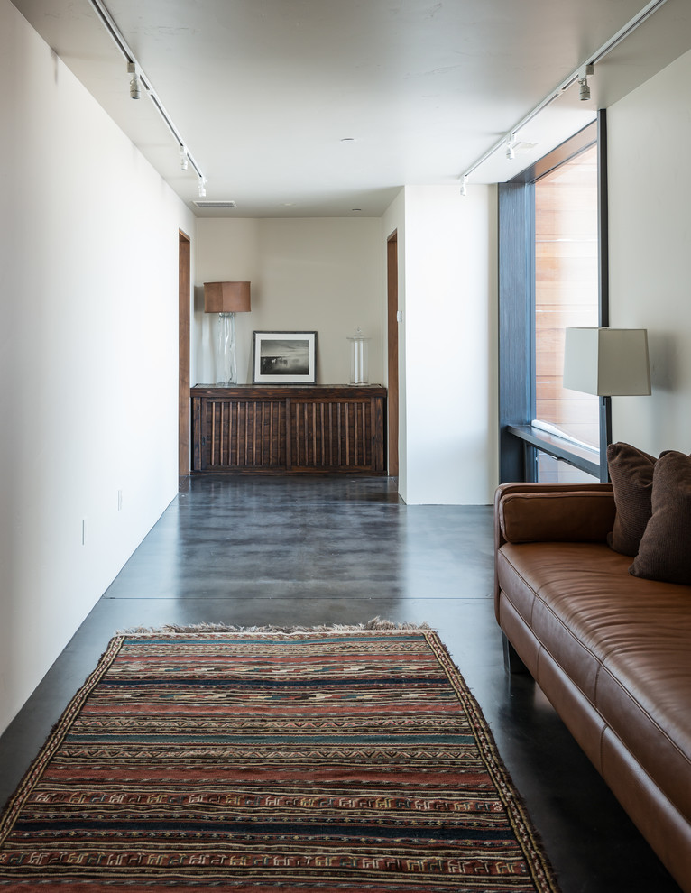 Expansive contemporary hallway in Other with white walls, concrete floors and grey floor.