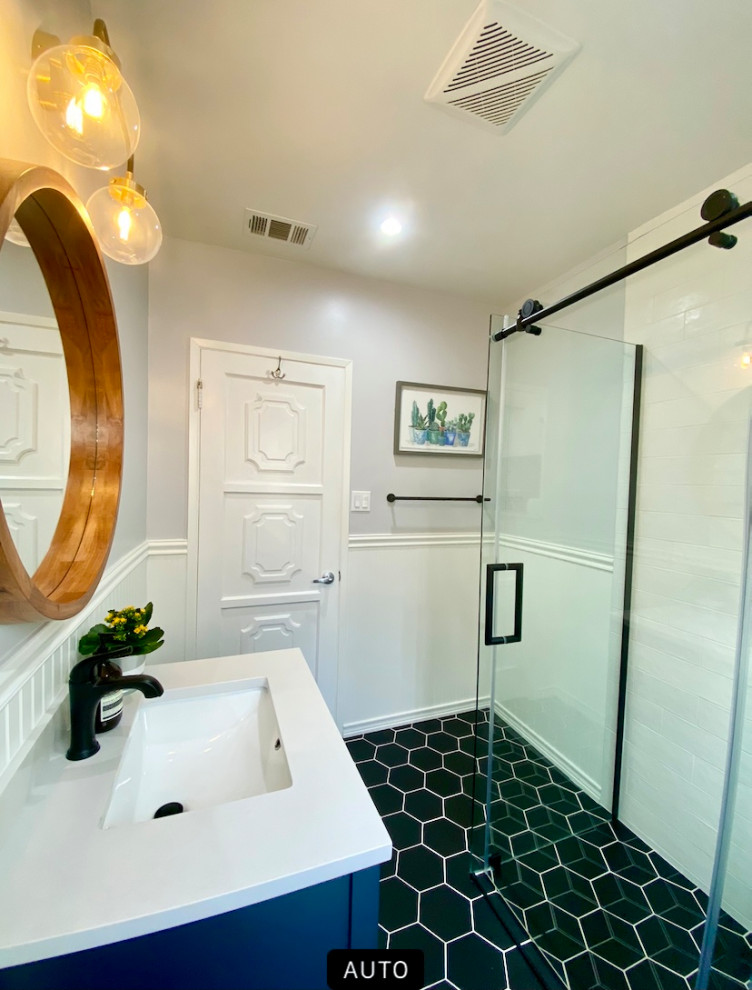 Пример оригинального дизайна: ванная комната среднего размера в стиле ретро с фасадами в стиле шейкер, синими фасадами, душем без бортиков, раздельным унитазом, белой плиткой, керамической плиткой, белыми стенами, полом из керамической плитки, душевой кабиной, врезной раковиной, мраморной столешницей, черным полом, душем с раздвижными дверями, белой столешницей, нишей, тумбой под одну раковину, встроенной тумбой и панелями на стенах