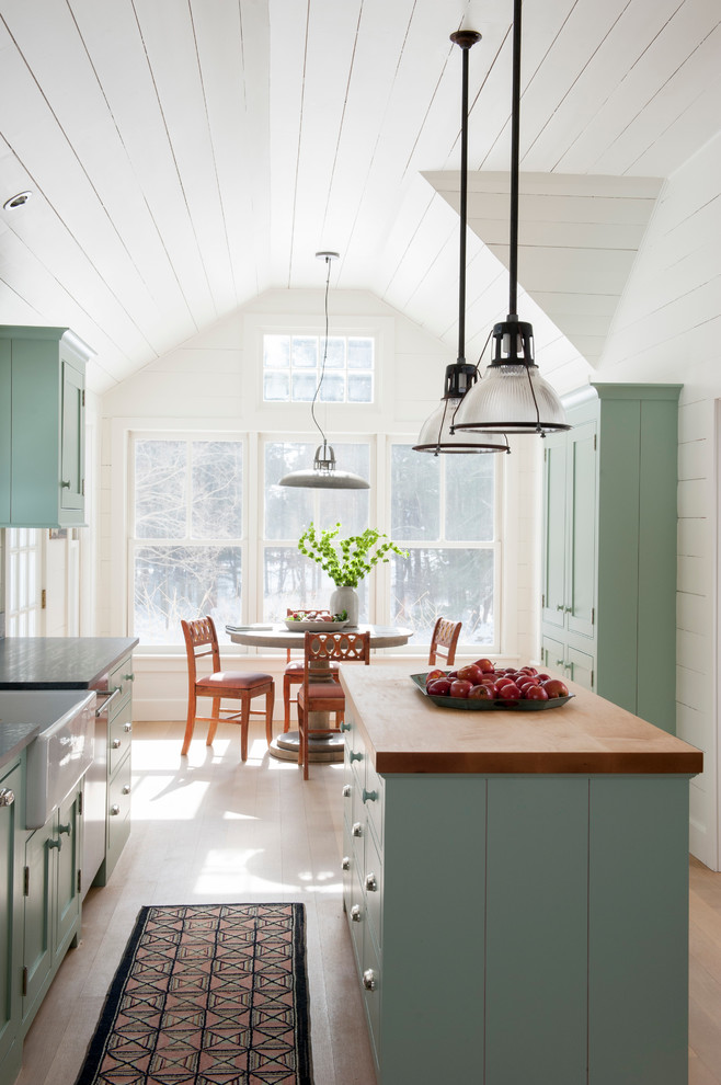 Design ideas for a mid-sized country galley eat-in kitchen in New York with a farmhouse sink, beaded inset cabinets, blue cabinets, soapstone benchtops and with island.