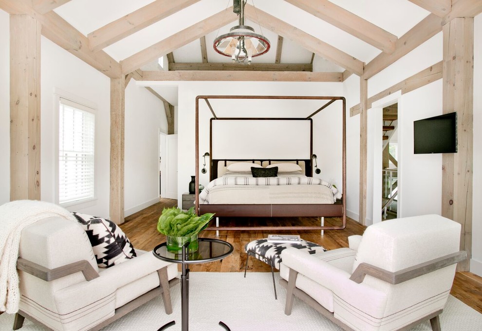 Inspiration for a large country master bedroom in New York with white walls, brown floor and medium hardwood floors.
