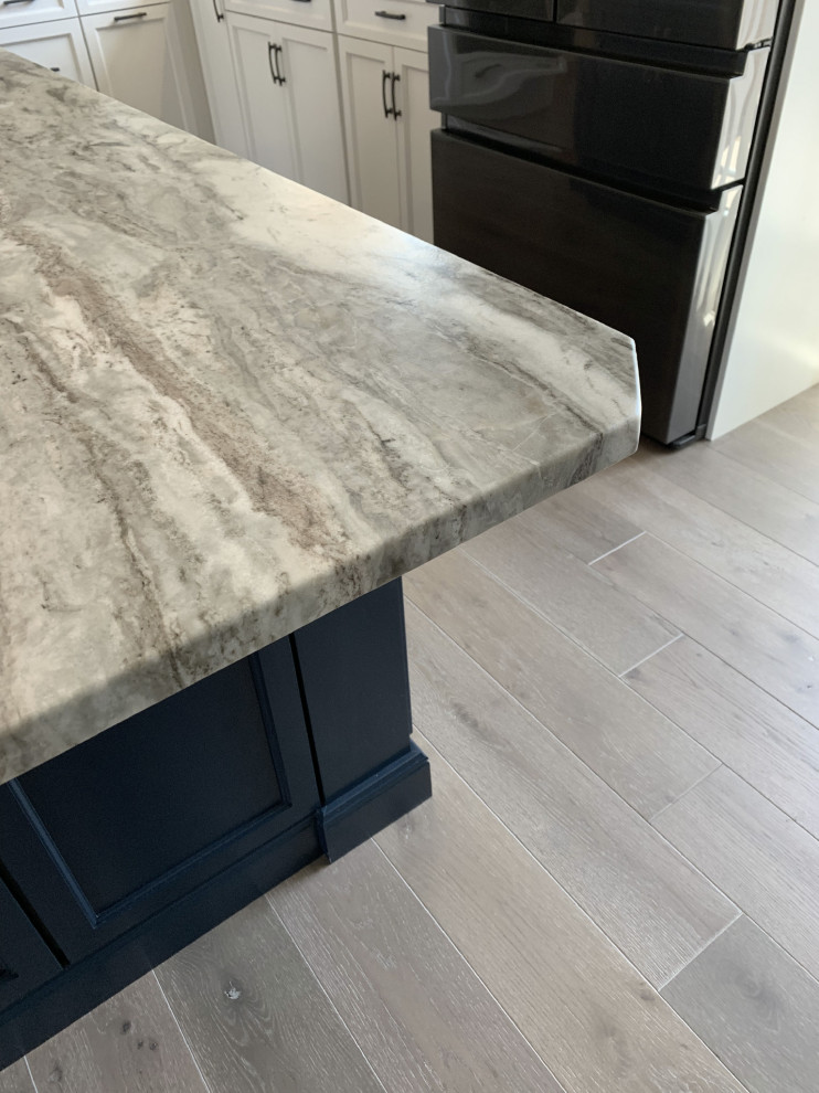 Eat-in kitchen - large transitional l-shaped vinyl floor and gray floor eat-in kitchen idea with an undermount sink, recessed-panel cabinets, white cabinets, quartz countertops, gray backsplash, ceramic backsplash, stainless steel appliances, an island and white countertops
