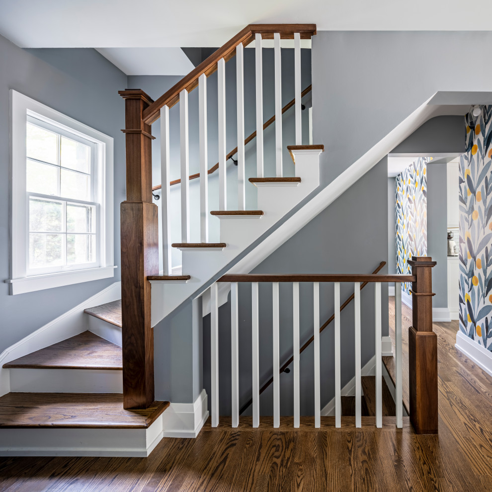 Идея дизайна: изогнутая лестница в стиле неоклассика (современная классика) с деревянными перилами