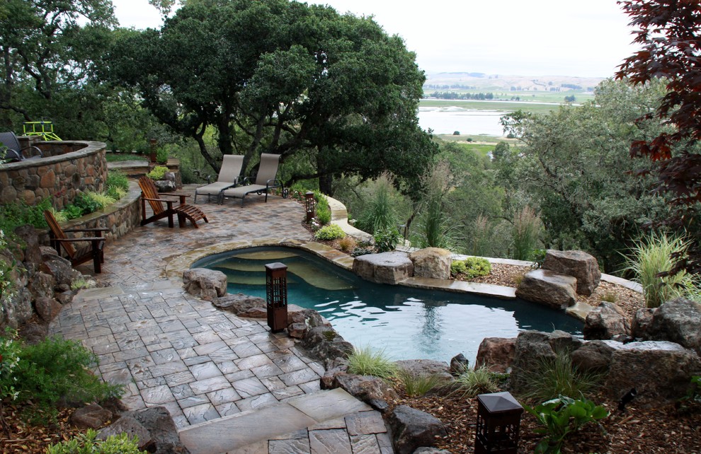 Inspiration for a large country backyard custom-shaped pool in San Francisco with a water feature and concrete pavers.
