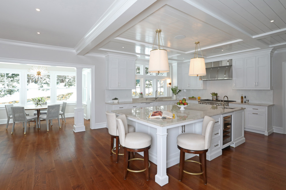 Inspiration for a large transitional l-shaped eat-in kitchen in New York with a double-bowl sink, shaker cabinets, white cabinets, quartzite benchtops, white splashback, glass tile splashback, panelled appliances, light hardwood floors, with island, brown floor, beige benchtop and coffered.