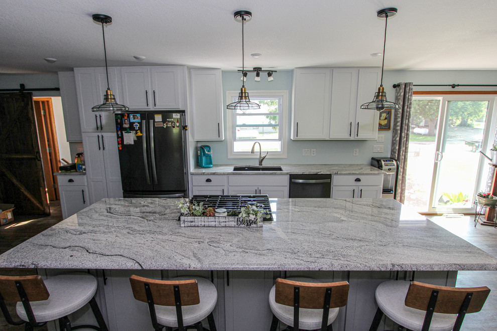 Example of a mid-sized transitional single-wall laminate floor and brown floor open concept kitchen design in Minneapolis with an undermount sink, shaker cabinets, gray cabinets, granite countertops, stainless steel appliances, an island and gray countertops