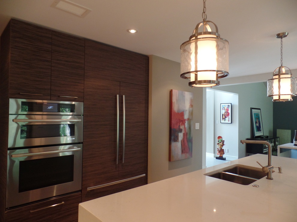 Enclosed kitchen - mid-sized transitional l-shaped porcelain tile and beige floor enclosed kitchen idea with an undermount sink, flat-panel cabinets, medium tone wood cabinets, quartz countertops, white backsplash, subway tile backsplash, paneled appliances and an island