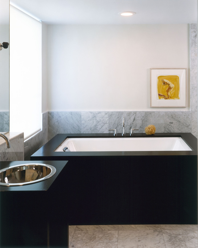 Contemporary bathroom in New York with a drop-in sink, an undermount tub and gray tile.