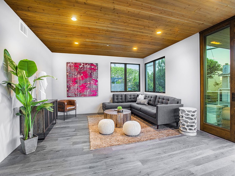 This is an example of a large contemporary formal open concept living room in San Diego with grey walls, light hardwood floors, no fireplace, no tv and grey floor.