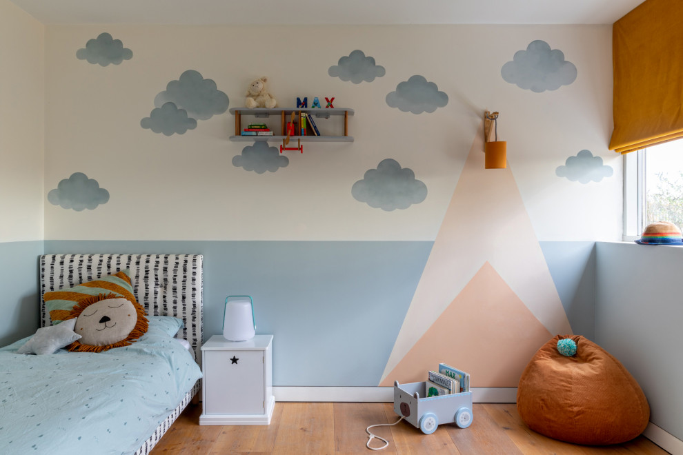 Photo of a medium sized contemporary kids' bedroom in London with multi-coloured walls and light hardwood flooring.