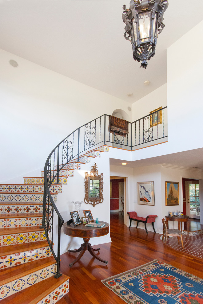 Photo of a mediterranean wood curved staircase in Santa Barbara with tile risers.