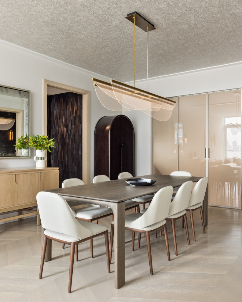 Photo of a mid-sized contemporary dining room in New York with white walls, light hardwood floors, beige floor and wallpaper.