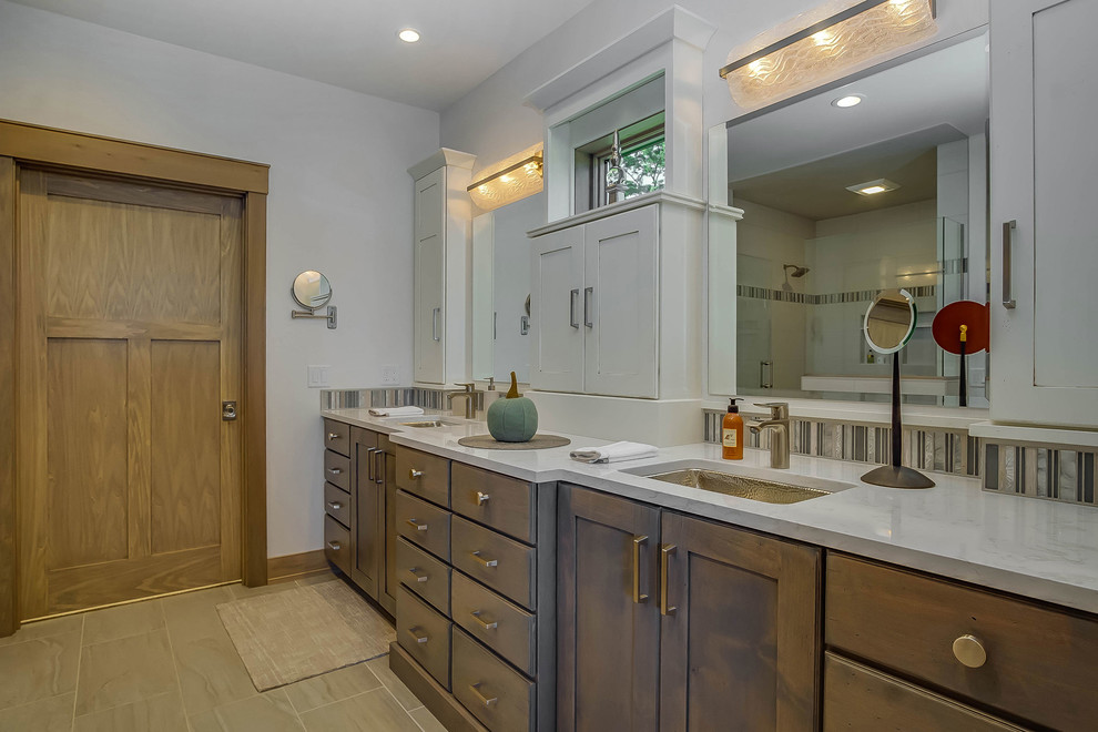 Mid-sized arts and crafts master bathroom in Grand Rapids with shaker cabinets, dark wood cabinets, an alcove shower, a two-piece toilet, multi-coloured tile, mosaic tile, white walls, porcelain floors, an undermount sink, engineered quartz benchtops, beige floor and a hinged shower door.