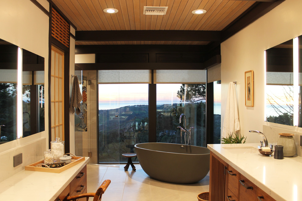 Large asian master bathroom in Los Angeles with flat-panel cabinets, a freestanding tub, a curbless shower, a bidet, gray tile, white walls, porcelain floors, an undermount sink, quartzite benchtops, grey floor, a hinged shower door and medium wood cabinets.