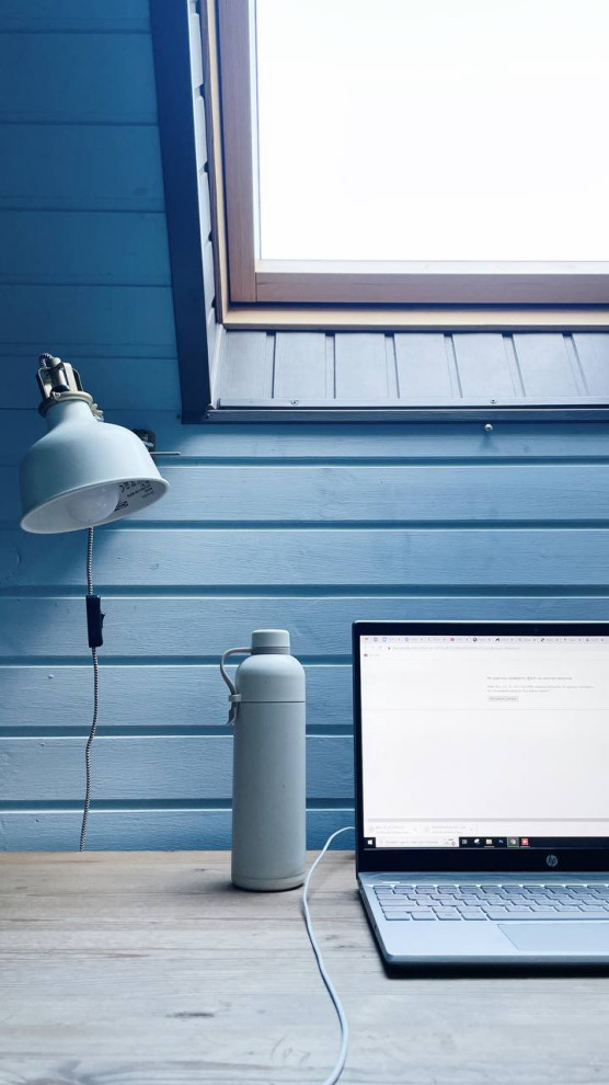 Foto de despacho contemporáneo de tamaño medio con paredes azules, suelo laminado, escritorio independiente, suelo beige, papel pintado y machihembrado