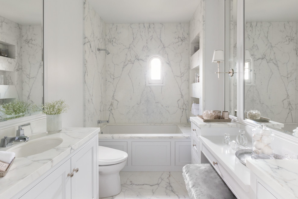 This is an example of a large contemporary master bathroom in San Francisco with white cabinets, an alcove tub, a shower/bathtub combo, a bidet, white tile, marble, white walls, marble floors, a drop-in sink, marble benchtops, white floor, white benchtops and an open shower.
