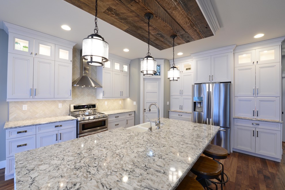 Large medium tone wood floor eat-in kitchen photo with a double-bowl sink, recessed-panel cabinets, white cabinets, quartzite countertops, multicolored backsplash, ceramic backsplash, stainless steel appliances and an island