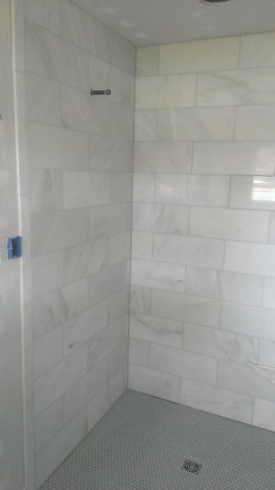 This is an example of a small traditional master bathroom in Austin with a curbless shower, white tile, stone tile and mosaic tile floors.