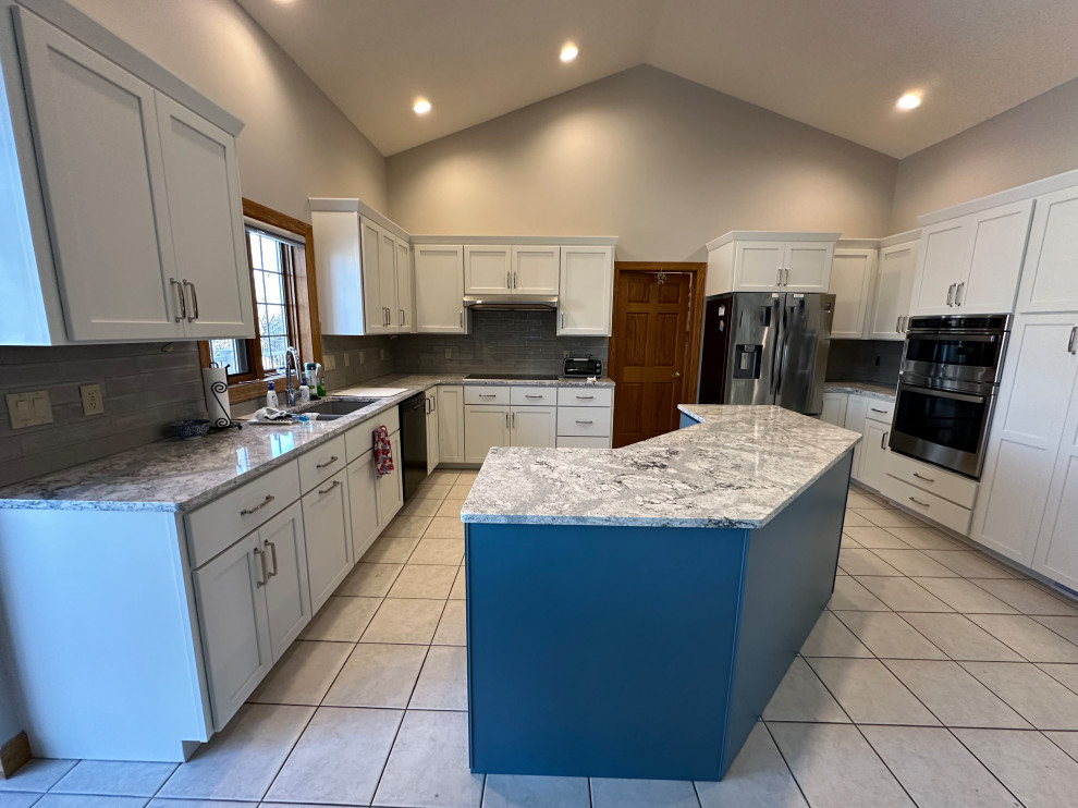 Photo of a large transitional u-shaped eat-in kitchen in Other with shaker cabinets, white cabinets, quartz benchtops, grey splashback, porcelain splashback and with island.