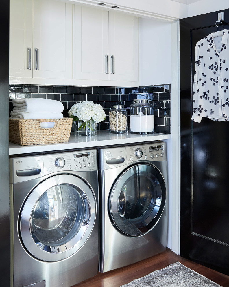 Small transitional single-wall laundry cupboard in San Francisco with white cabinets, marble benchtops, a side-by-side washer and dryer, shaker cabinets, dark hardwood floors, brown floor, white benchtop and white walls.