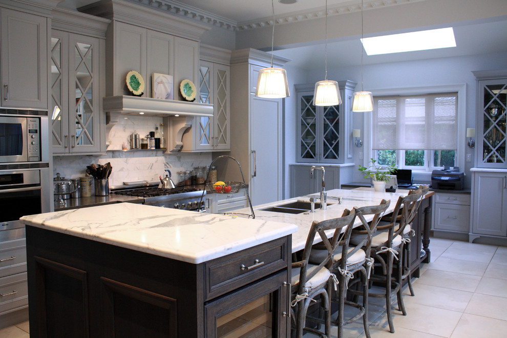 This is an example of a large transitional single-wall eat-in kitchen in Vancouver with a double-bowl sink, recessed-panel cabinets, grey cabinets, quartzite benchtops, white splashback, ceramic splashback, panelled appliances, porcelain floors, with island, beige floor and white benchtop.
