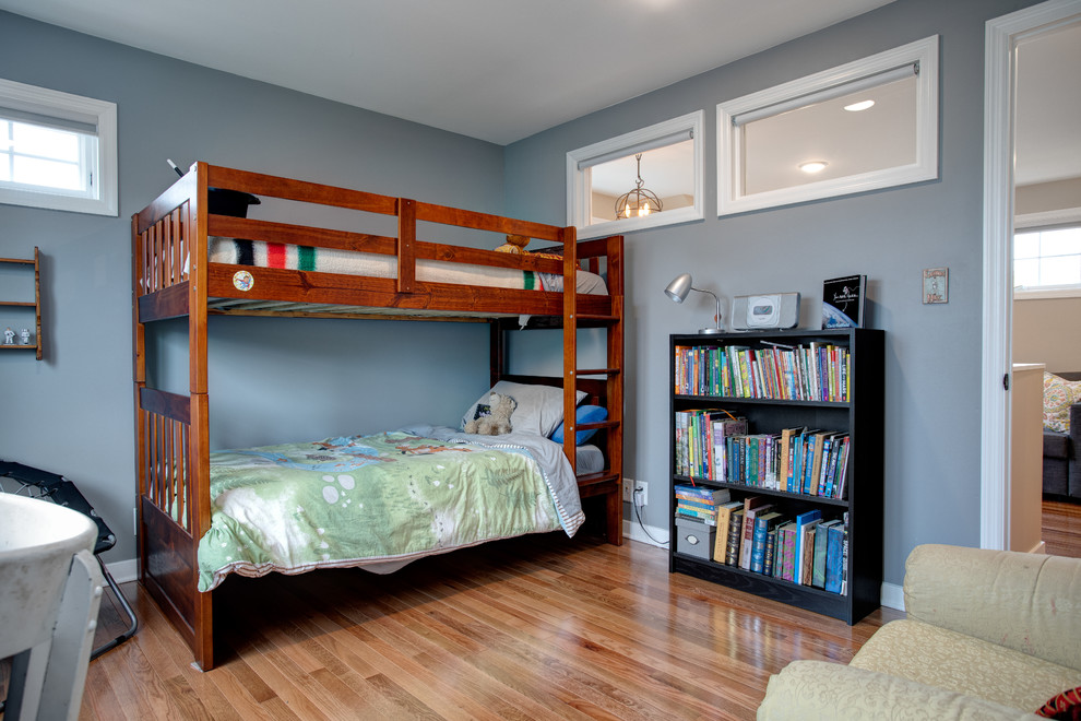 Photo of a mid-sized transitional kids' bedroom for boys in Minneapolis with blue walls, medium hardwood floors and brown floor.