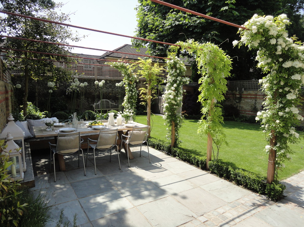 This is an example of a mid-sized contemporary backyard patio in London with no cover.