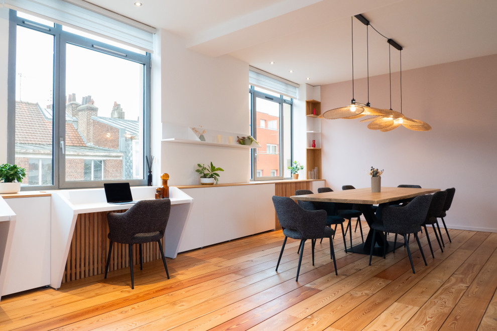 Large scandinavian dining room in Lille with pink walls, medium hardwood flooring, no fireplace and feature lighting.
