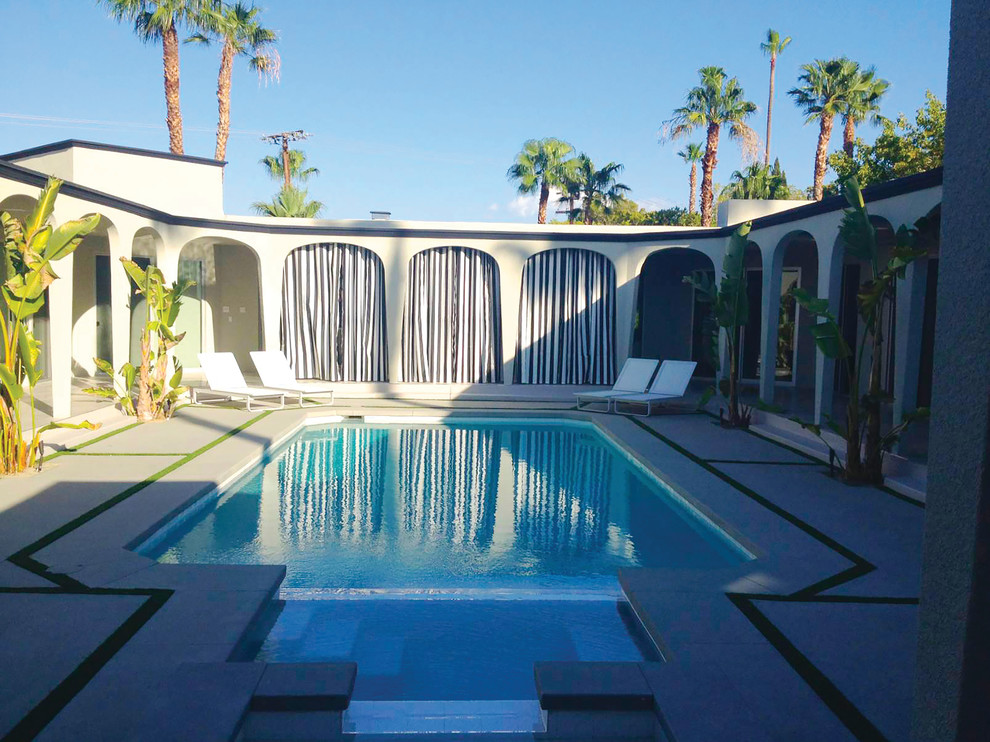 Inspiration for an expansive midcentury courtyard rectangular pool in Other with concrete slab and a hot tub.
