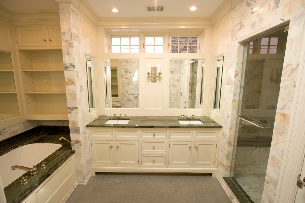 Photo of a large transitional master bathroom in Chicago with white cabinets, a drop-in tub, beige tile, porcelain tile, beige walls, an undermount sink, an alcove shower, linoleum floors, soapstone benchtops, furniture-like cabinets, grey floor and a hinged shower door.