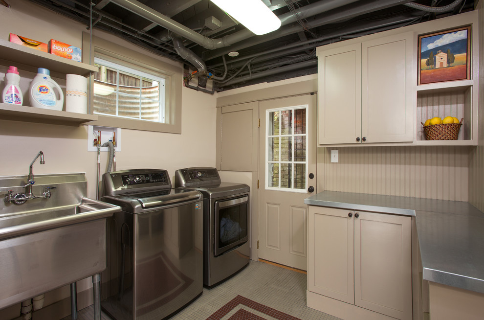 Inspiration for a mid-sized contemporary u-shaped dedicated laundry room in DC Metro with an utility sink, recessed-panel cabinets, beige cabinets, stainless steel benchtops, beige walls, porcelain floors and a side-by-side washer and dryer.
