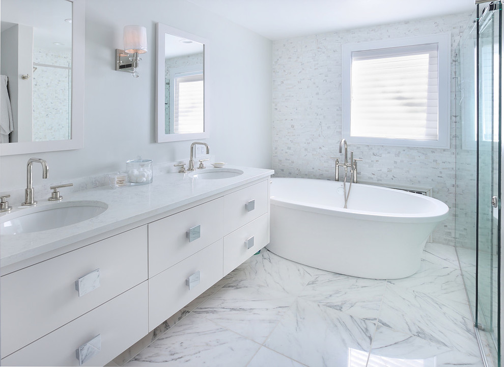Inspiration for a mid-sized transitional master bathroom in New York with flat-panel cabinets, white cabinets, a freestanding tub, an alcove shower, a two-piece toilet, white tile, mosaic tile, white walls, marble floors, an undermount sink, quartzite benchtops, white floor, a sliding shower screen and white benchtops.