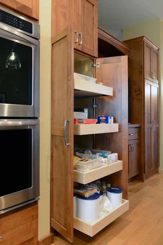 Mid-sized transitional u-shaped light wood floor open concept kitchen photo with an undermount sink, shaker cabinets, medium tone wood cabinets, granite countertops, glass tile backsplash, stainless steel appliances and an island