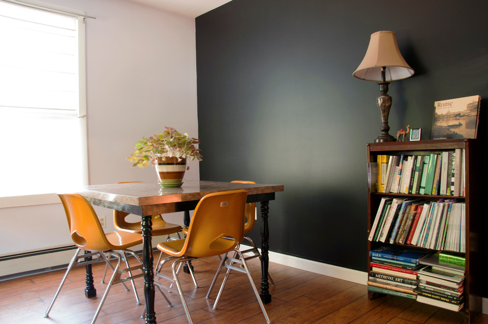 This is an example of a small contemporary home office in Portland Maine with black walls, medium hardwood floors, no fireplace and a freestanding desk.