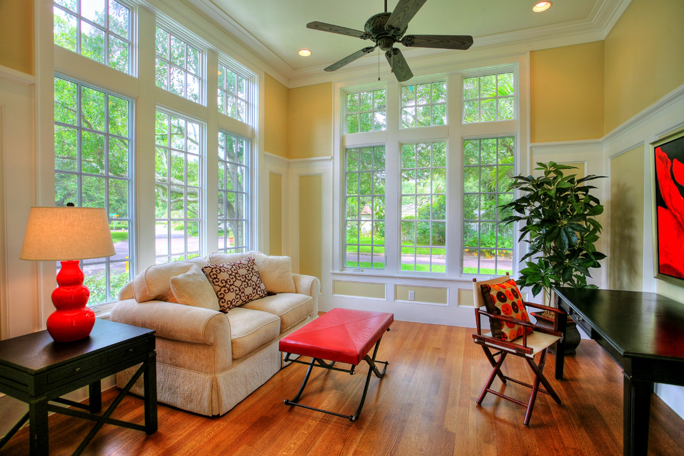 This is an example of a tropical family room in Tampa with beige walls and medium hardwood floors.