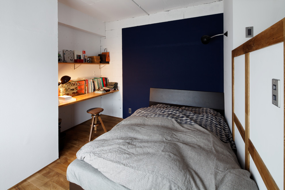 Inspiration for a small modern bedroom in Other with multi-coloured walls, medium hardwood floors and brown floor.