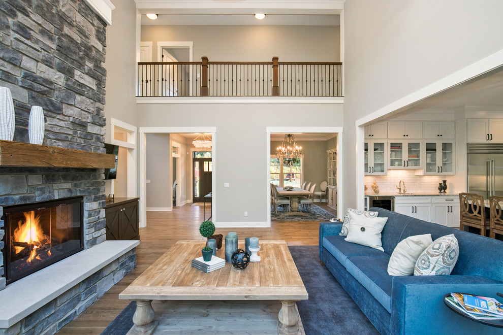 Inspiration for a traditional open concept living room in Grand Rapids with grey walls, medium hardwood floors, a standard fireplace, no tv and brown floor.