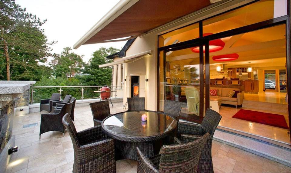 Inspiration for a large contemporary metal railing balcony in Other with an awning and a fireplace.