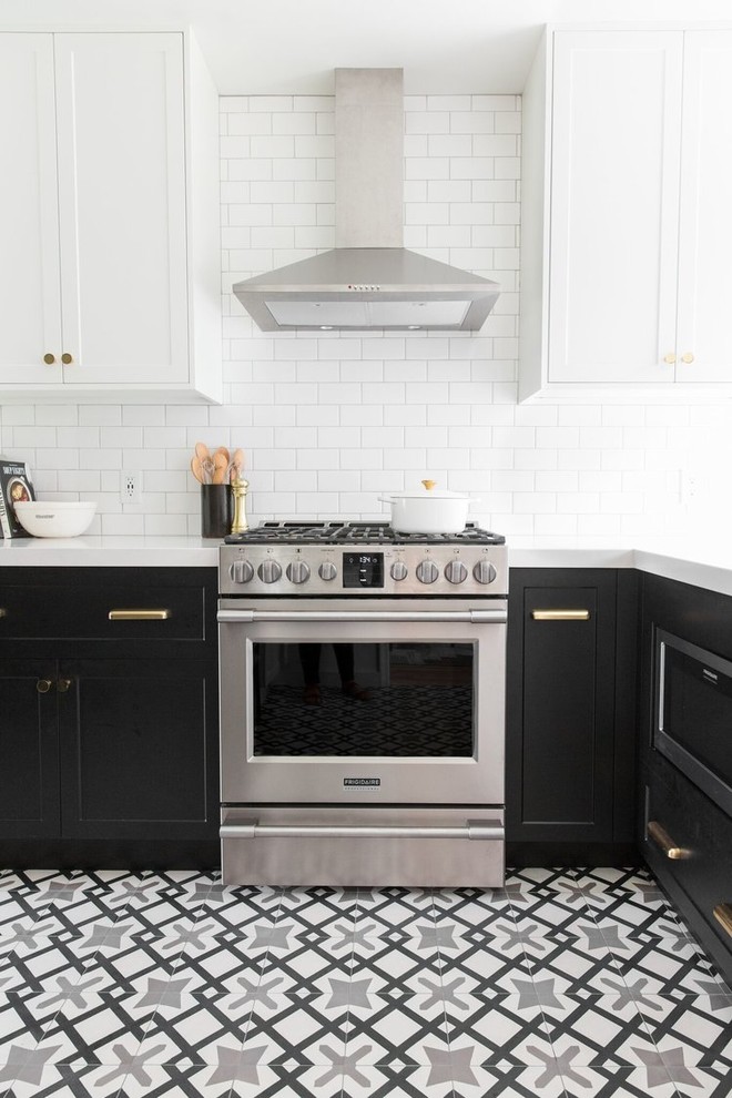 Photo of a mid-sized transitional l-shaped separate kitchen in Salt Lake City with a drop-in sink, white cabinets, white splashback, subway tile splashback, stainless steel appliances, cement tiles and multi-coloured floor.
