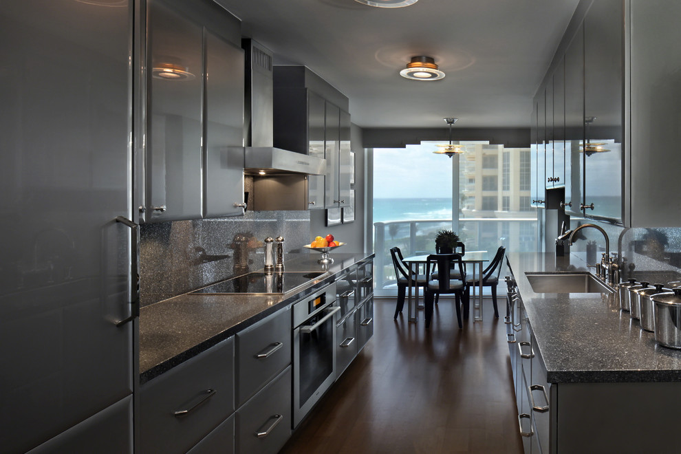 This is an example of a mid-sized modern galley eat-in kitchen in Miami with an undermount sink, flat-panel cabinets, grey cabinets, terrazzo benchtops, stone slab splashback, stainless steel appliances, dark hardwood floors and no island.