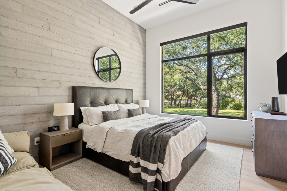 Ejemplo de habitación de invitados contemporánea con paredes blancas y suelo de madera clara