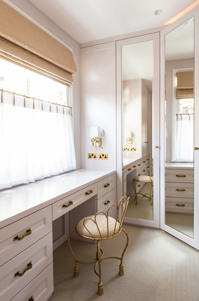 Inspiration for a mid-sized contemporary storage and wardrobe in London with white cabinets.
