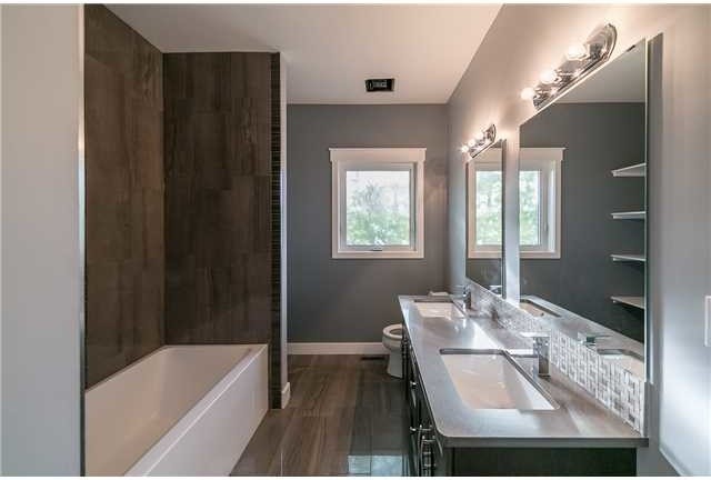 Large contemporary master bathroom in Edmonton with dark wood cabinets, an alcove tub, a corner shower, a two-piece toilet, grey walls, painted wood floors and an undermount sink.