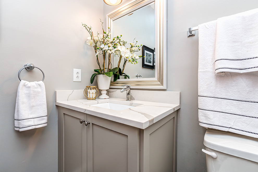 Inspiration for a mid-sized transitional powder room in Charlotte with shaker cabinets, grey cabinets, grey walls, an undermount sink, marble benchtops and white benchtops.