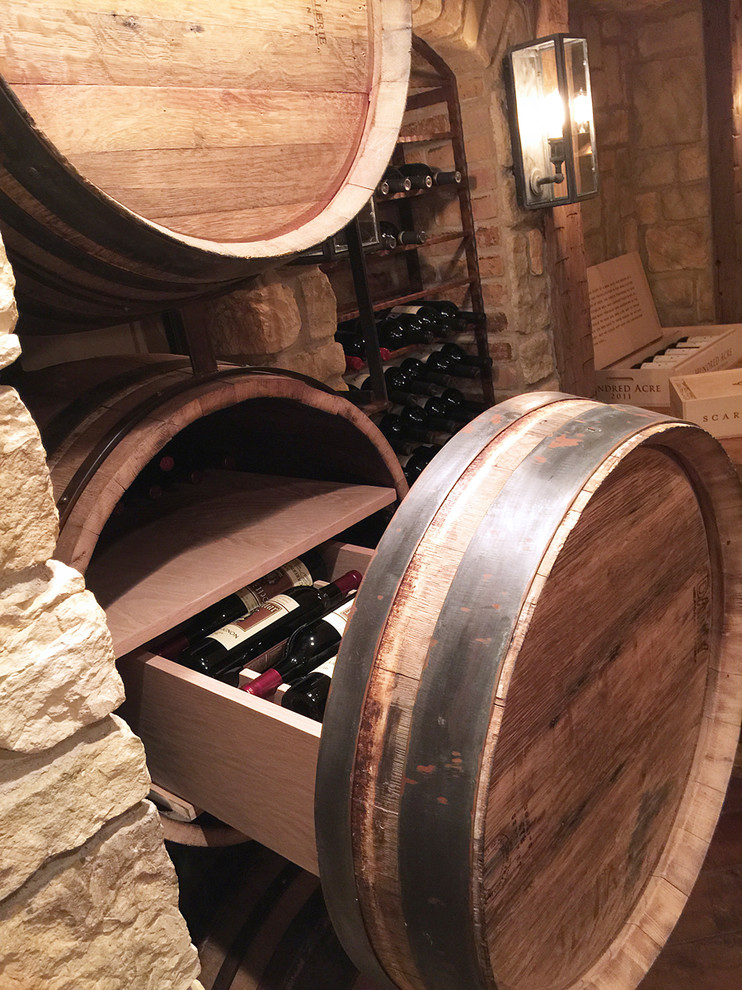 Mid-sized country wine cellar in Chicago with terra-cotta floors, storage racks and brown floor.