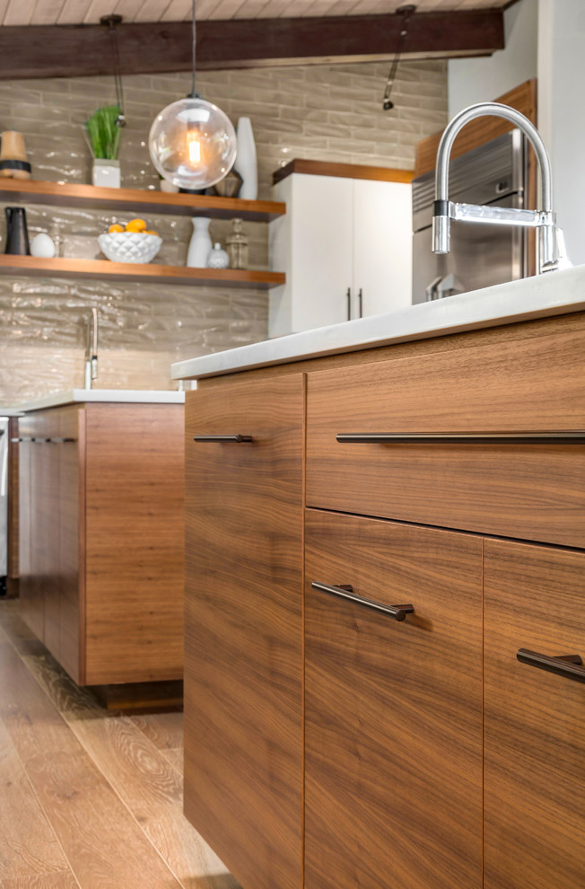 Large midcentury l-shaped open plan kitchen in Portland with an undermount sink, flat-panel cabinets, light wood cabinets, quartzite benchtops, beige splashback, stainless steel appliances, light hardwood floors, with island and beige floor.