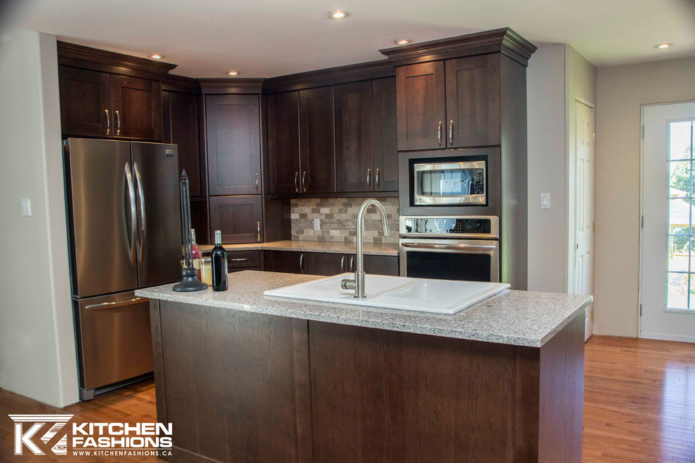 Open concept kitchen - large transitional u-shaped medium tone wood floor open concept kitchen idea with a farmhouse sink, shaker cabinets, dark wood cabinets, quartz countertops, brown backsplash, stone tile backsplash, stainless steel appliances and an island
