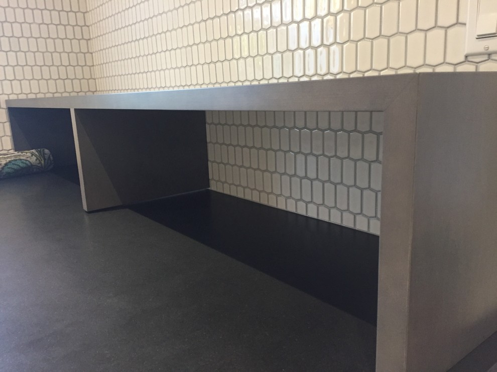 Example of a mid-sized transitional u-shaped concrete floor and gray floor home design design with an undermount sink, flat-panel cabinets, white cabinets, a side-by-side washer/dryer and black countertops